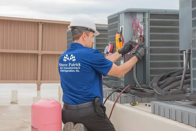 Technician using test equipment on an outdoor HVAC system